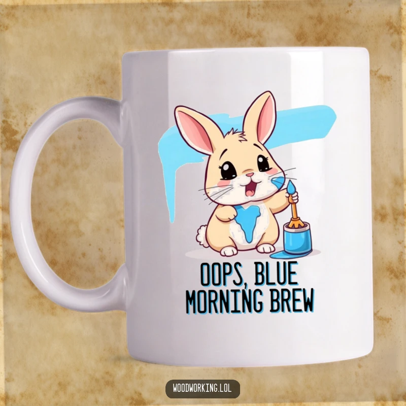 Funny rabbit mug showing a surprised rabbit accidentally splattered with bright blue paint, embodying artistic mishaps.
